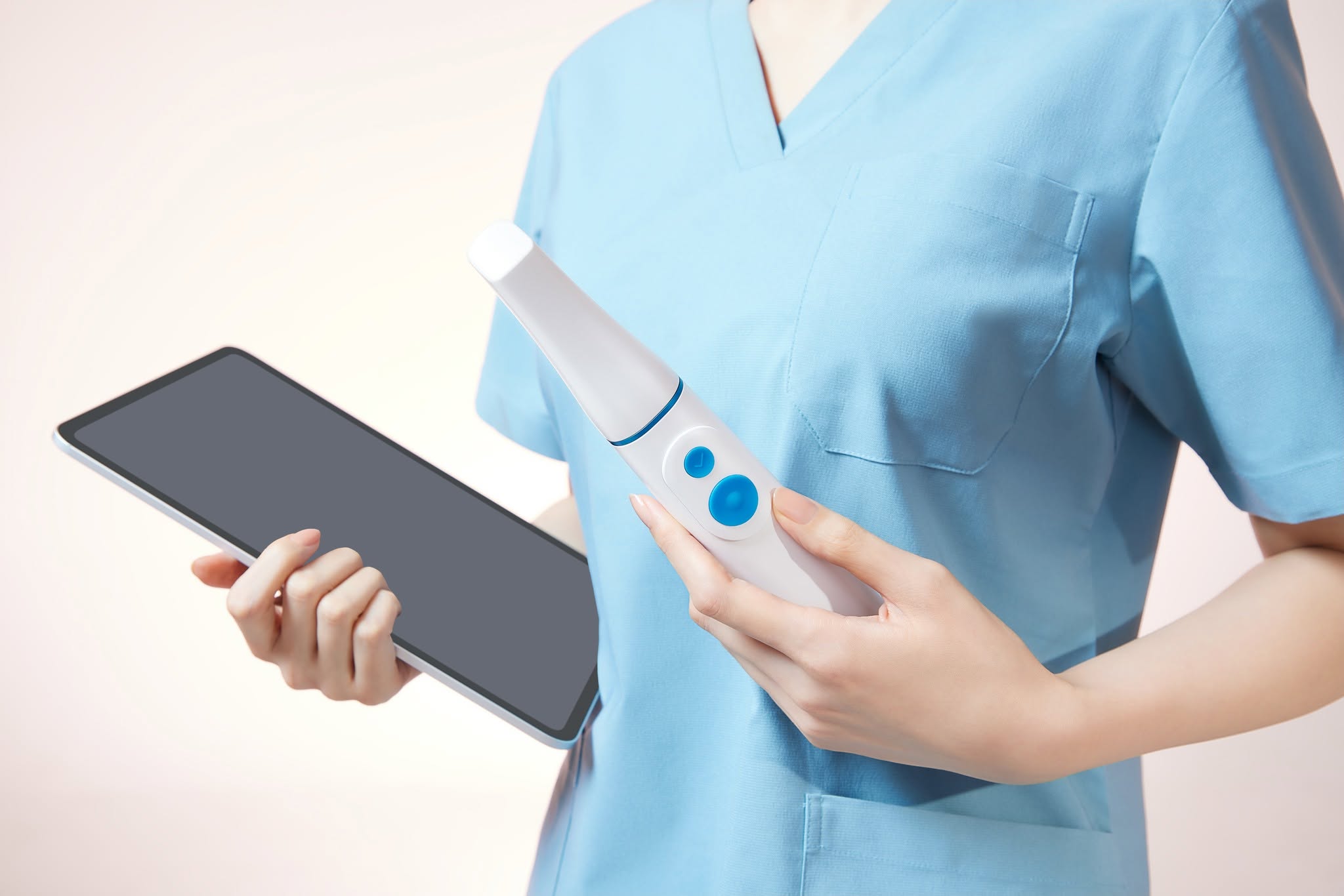 Dental professional holding the Medit i900 Mobility scanner and an iPad